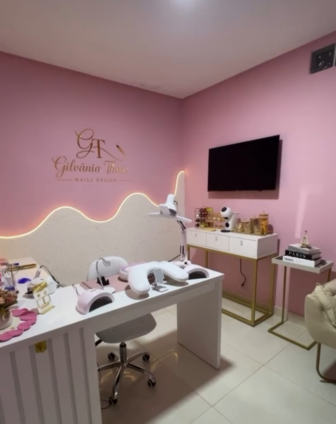Studio Gilvania Thays, com bancada de atendimento e decoração rosa e dourada